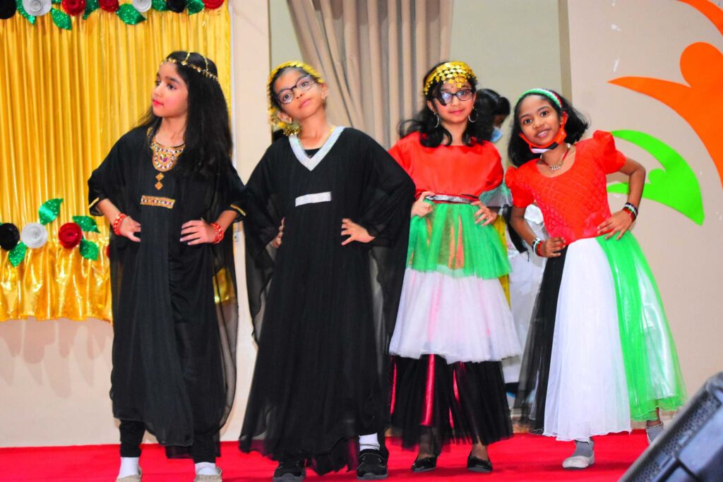 DPS Ajman students in UAE flag colour costumes performing on stage for UAE National Day