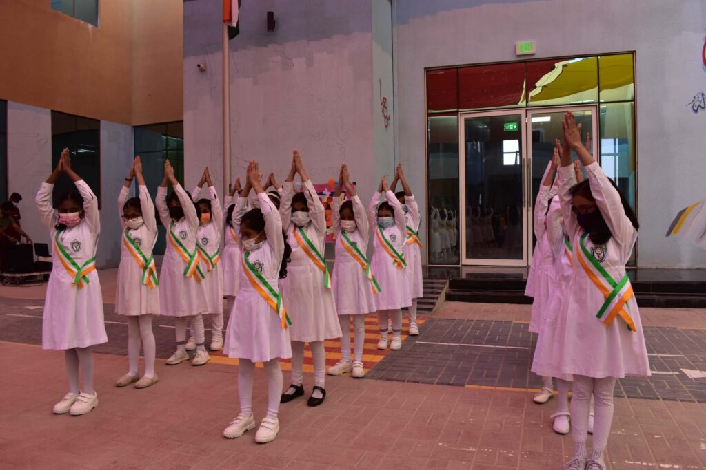 Students in sashes lined up on campus for a school ceremony at DPS Ajman